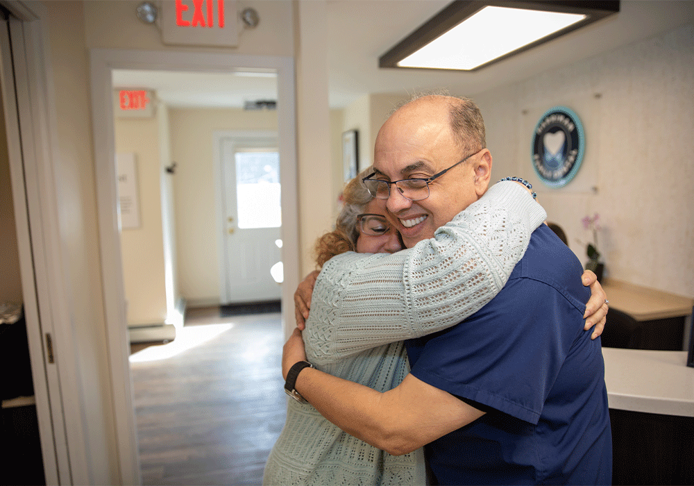 Dr. Radwan hugging a patient