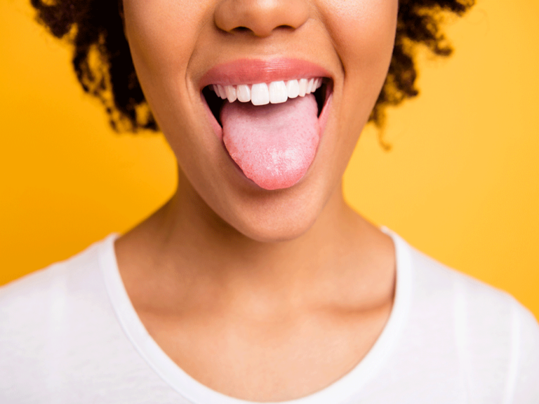 Woman opening her mouth, smiling and sticking her tongue out at the camera.